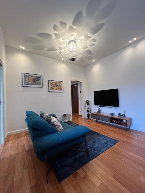 a living room with a blue couch and a flat screen tv at Lattanzio Charming Suite - Porta Romana MM3 in Milan