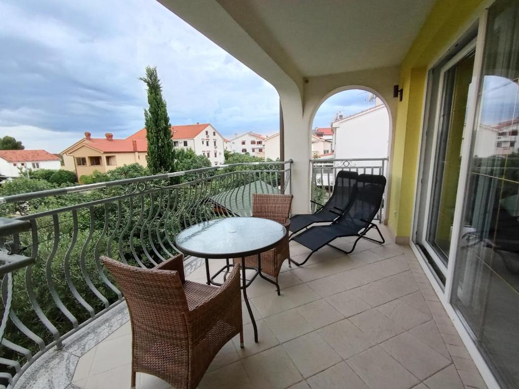 a patio with a table and chairs on a balcony at Ana Rooms in Krk
