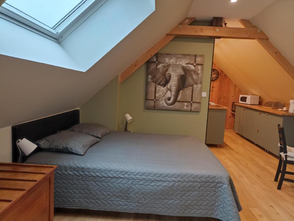 une chambre avec un lit avec une photo d'éléphant sur le mur dans l'établissement Le petit Herils, à Maisons