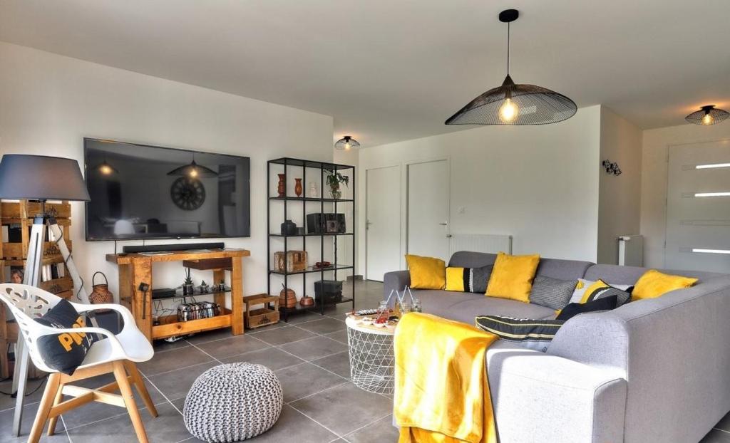 a living room with a couch and a tv at Cap Coz Cottage 4* a 500 m de la plage de sable fin in Fouesnant
