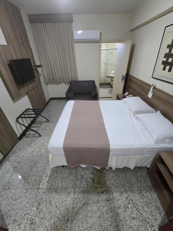 um quarto de hotel com uma cama grande e uma televisão em Via Contorno Hotel em Belo Horizonte