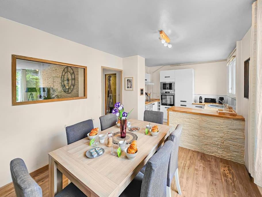 une salle à manger avec une table et des chaises et une cuisine dans l'établissement L'Escale Caennaise, à Caen