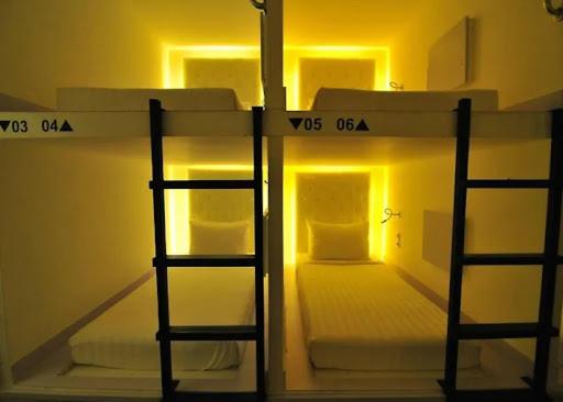 Honeycomb Capsule Hostel Near Burjuman and Sharaf dg metro في دبي: غرفة بسريرين بطابقين في غرفة