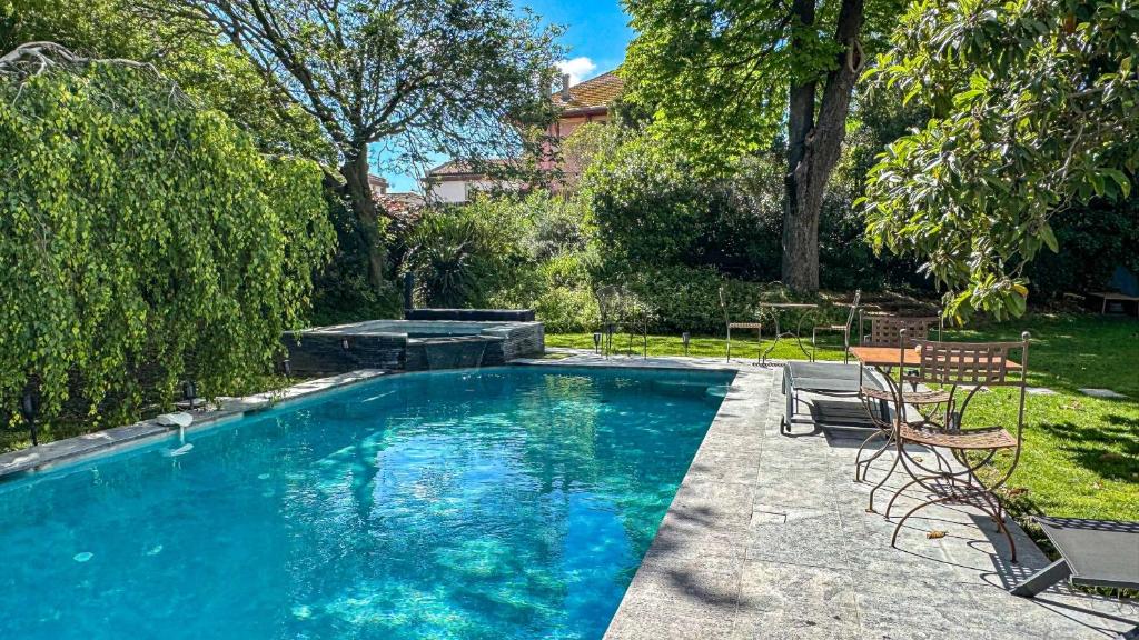 a swimming pool with two chairs in a yard at Demeure Saint Louis Historic manor, City 700m, parking,A C,Clim,WIFI, heated pool, city view in Carcassonne