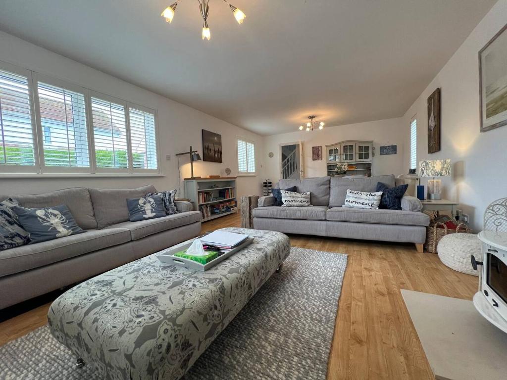 a living room with two couches and a table at Pass the Keys Whytecroft -Fabulous Family Fun in Camber