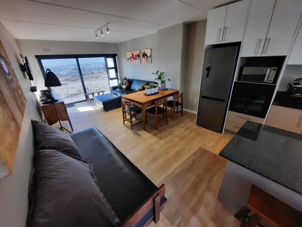 a kitchen and living room with a couch and a table at Nivica 54 Luxury Apartment in Langebaan