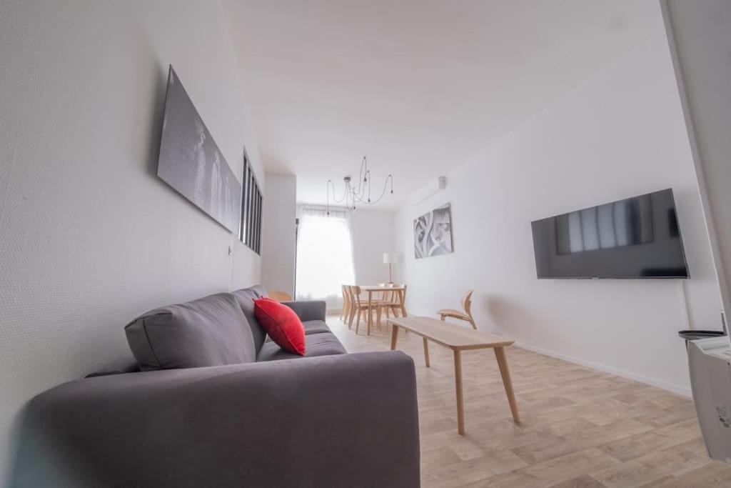 un salon avec un canapé et une table dans l'établissement L'Ange au Sourire, à Reims