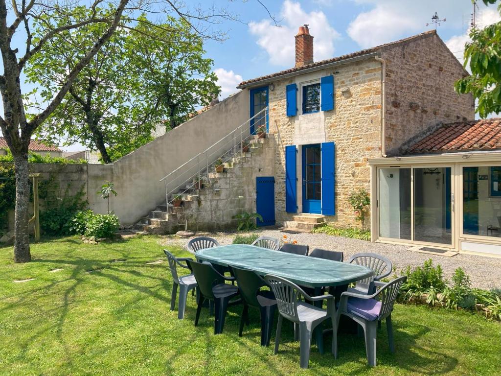 a table and chairs in the yard of a house at Gîte de charme avec spa privatif pour 4 à 6 personnes in Péault