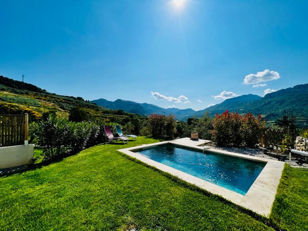 a swimming pool in a yard with mountains in the background at LOGIS DES ROCHES - 3 VILLAS VUE EXCEPTIONNELLE - Le Petit Chevalet, Le Grand Sabouillon & la Villa Opaya in Buis-les-Baronnies