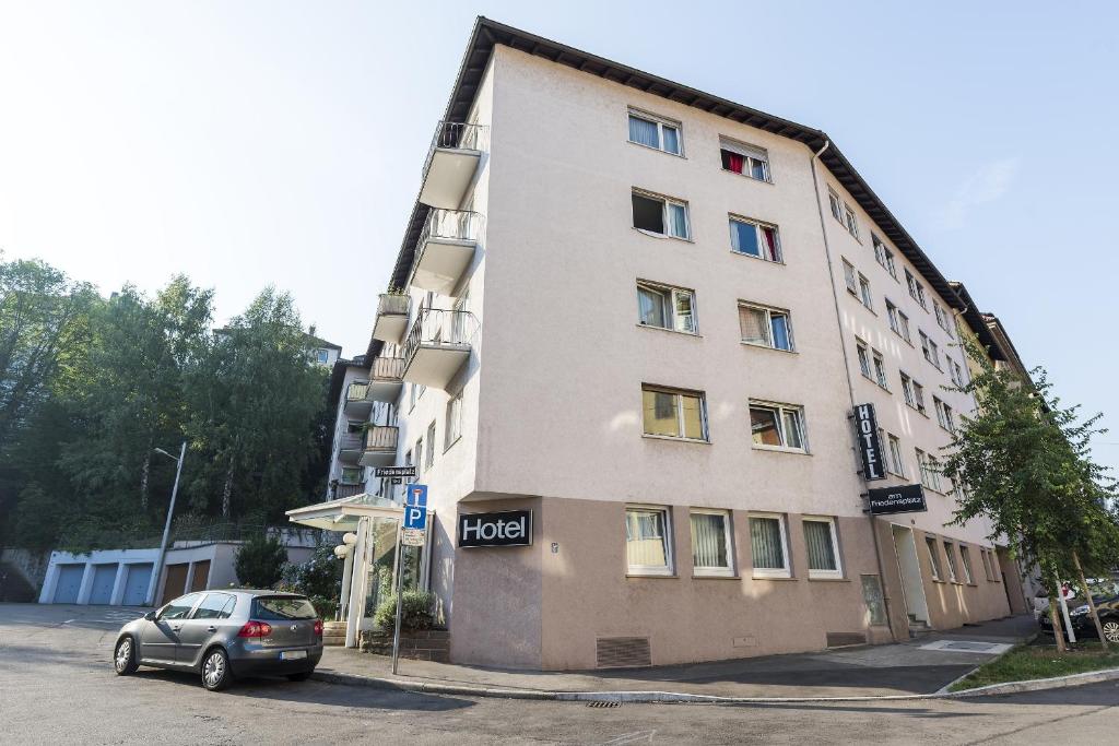 un coche aparcado frente a un edificio en Hotel am Friedensplatz en Stuttgart