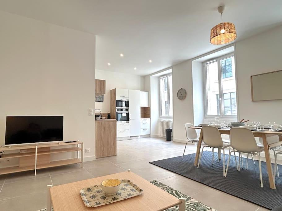 un salon avec une table à manger et une télévision dans l'établissement Bassin à flot, appartement lumineux et central, à Lorient