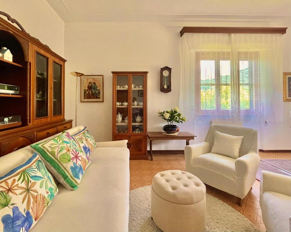 a living room with a white couch and a chair at Hostly - Villa Elisa - Between Pisa and Lucca in Avane