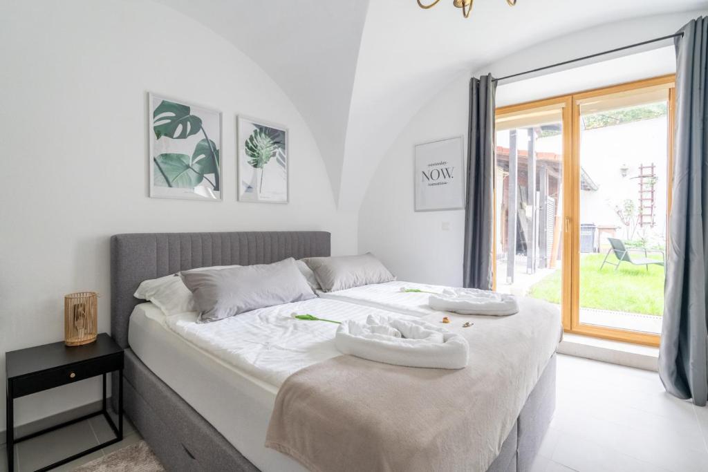 een slaapkamer met een groot wit bed en een raam bij Wachau Familienoase / 60m² / Gartenparadies in Mautern