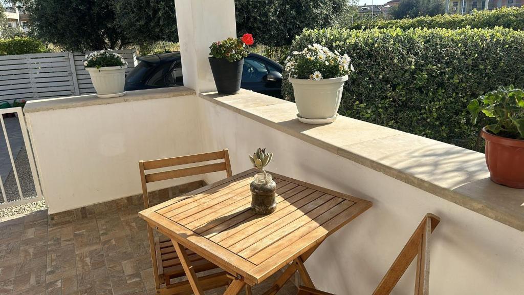 a small table and chairs on a balcony with potted plants at B&B AMURI RANNI in Avola