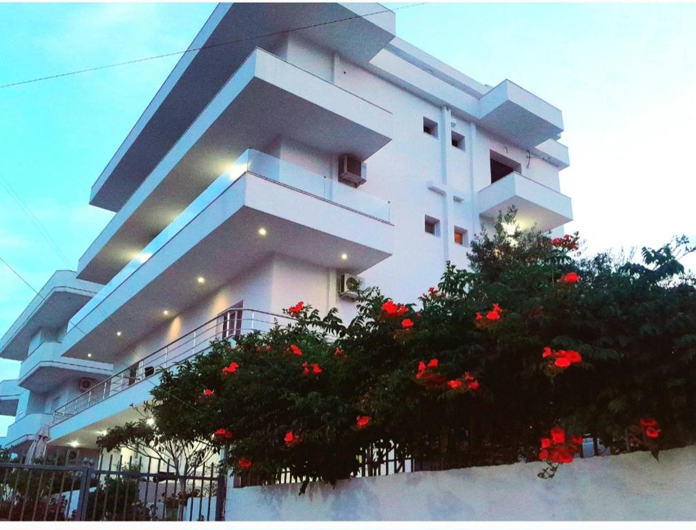 un edificio bianco con un albero di fronte di GB Rooms a Ksamil