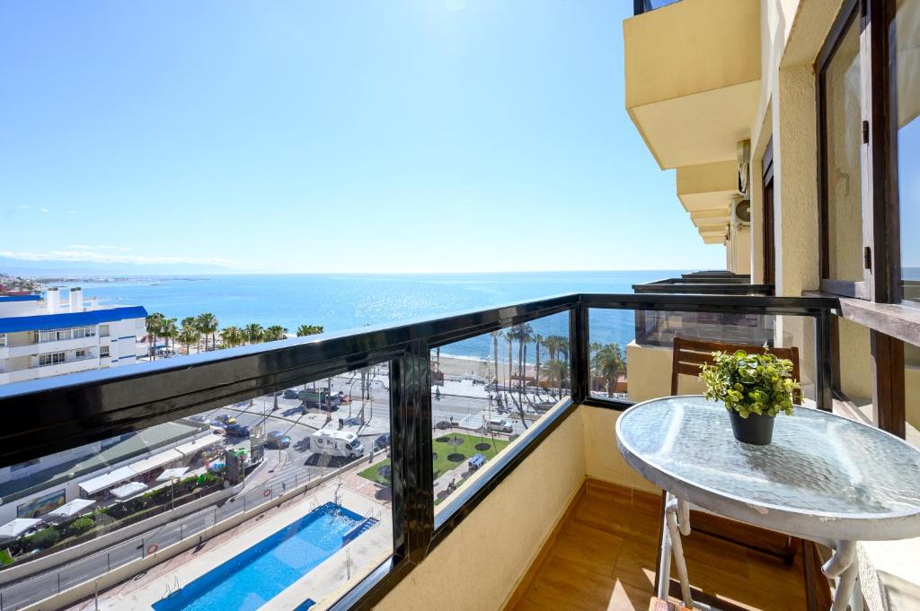 a balcony with a table and a view of the ocean at Benalmádena Living in Benalmádena