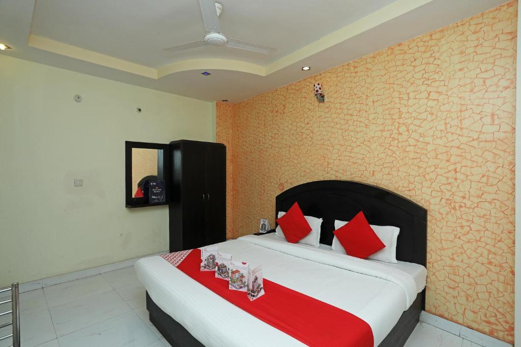 1 dormitorio con 1 cama grande con almohadas rojas en Flagship Hotel Neel Ganga, en Haridwar