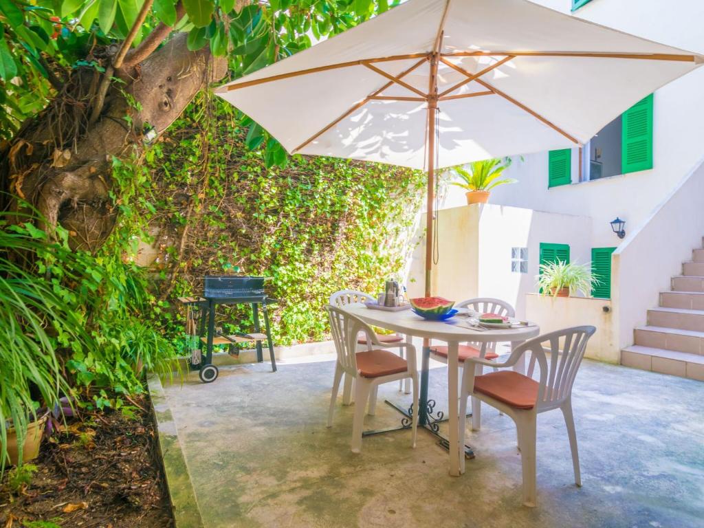 un tavolo e sedie con ombrellone su un patio di Casa Tradicional Can Picafort - Apartment In Can Picafort Free Wifi a Can Picafort