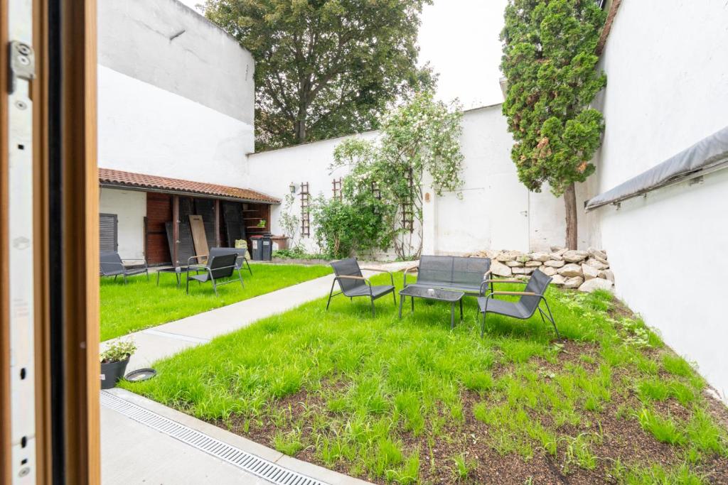 a patio with chairs and a table in the grass at Wachau Familienoase &#47; 60m² &#47; Gartenparadies in Mautern