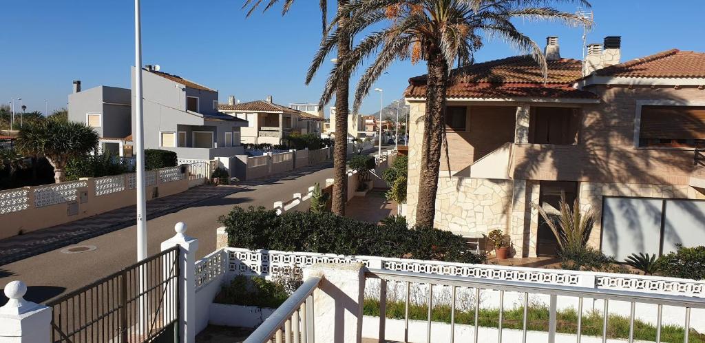 a street with a white fence and a house at Habitaciones a un paso del Mar en Cullera in Cullera