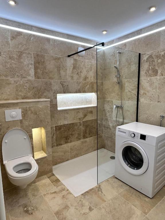 La salle de bains est pourvue de toilettes et d'un lave-linge. dans l'établissement La maison du Soleil, à Porticcio
