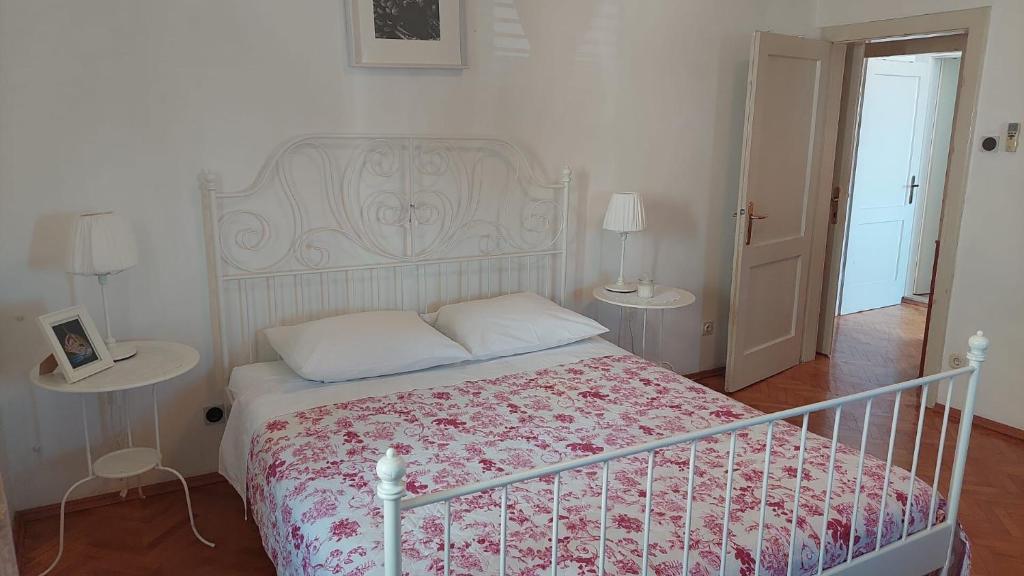 ein Schlafzimmer mit einem Bett und zwei Tischen mit Lampen in der Unterkunft Apartment Port in Makarska