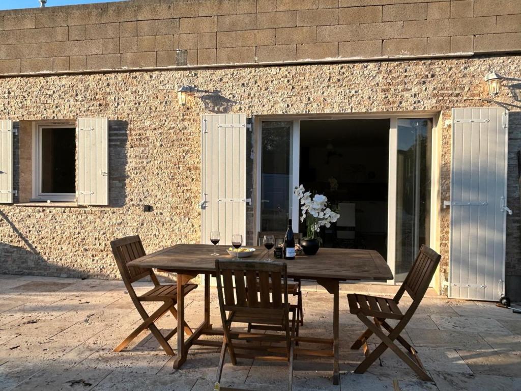 a wooden table and chairs in front of a building at La maison du Soleil in Porticcio