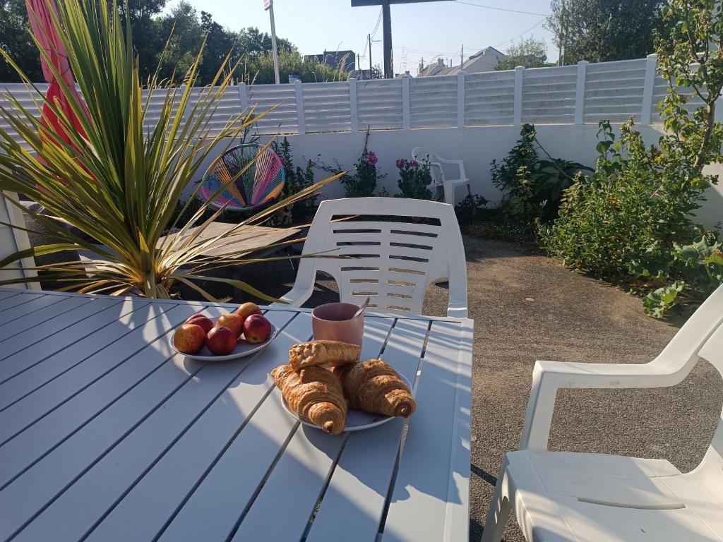 - une table avec une assiette de pain et des fruits dans l'établissement maison l'été à la plage, à Larmor-Plage
