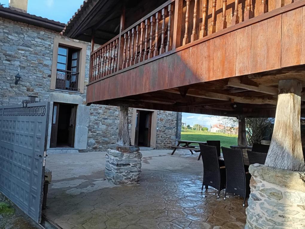a patio with a deck and a table and chairs at Casa de aldea La Caramba in Lamuño