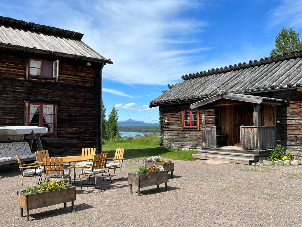 una cabaña de madera con una mesa y sillas frente a ella en Knappgården, en Särna