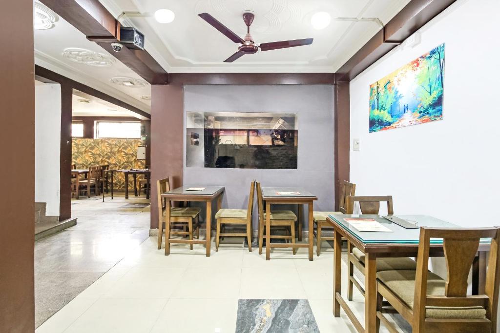City Star Hotel & Restaurant في Jawāharnagar: غرفة طعام مع طاولات وكراسي ومروحة سقف