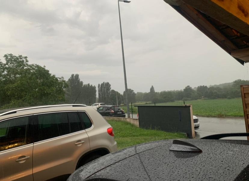 un'auto parcheggiata in un parcheggio sotto la pioggia di Chambre dans une villa a Beaupuy