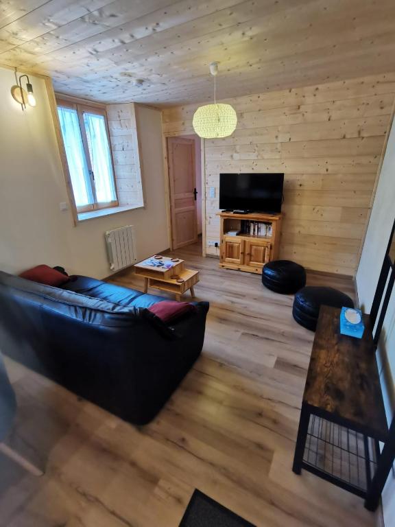 un salon avec un canapé et une télévision dans l'établissement Appartement en centre ville Au pied de l'Izoard, à Briançon