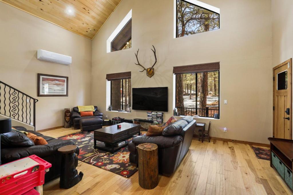 a living room with leather furniture and a flat screen tv at Bear Foot Lodge in Forest Lakes Estates