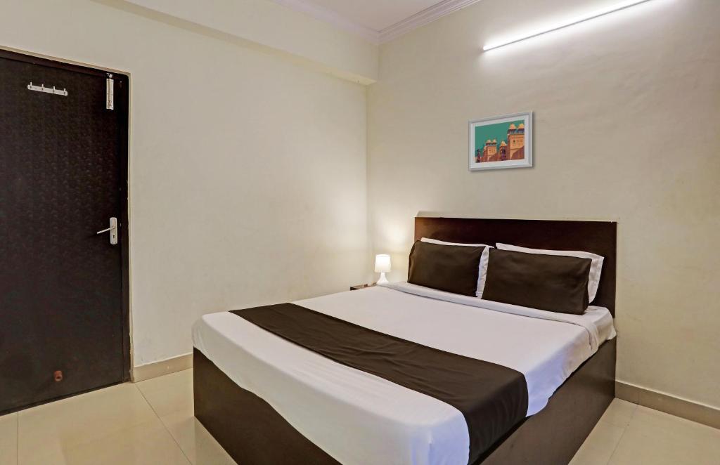ein Schlafzimmer mit einem Bett in einem Zimmer mit einer Tür in der Unterkunft OYO Flagship 35467 Shiridi Residency Near Birla Mandir in Hyderabad