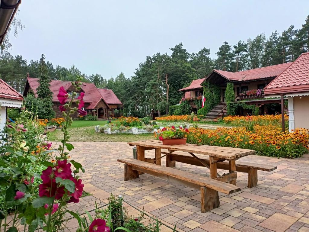 a wooden picnic table in a garden with flowers at Sosenka in Zalas