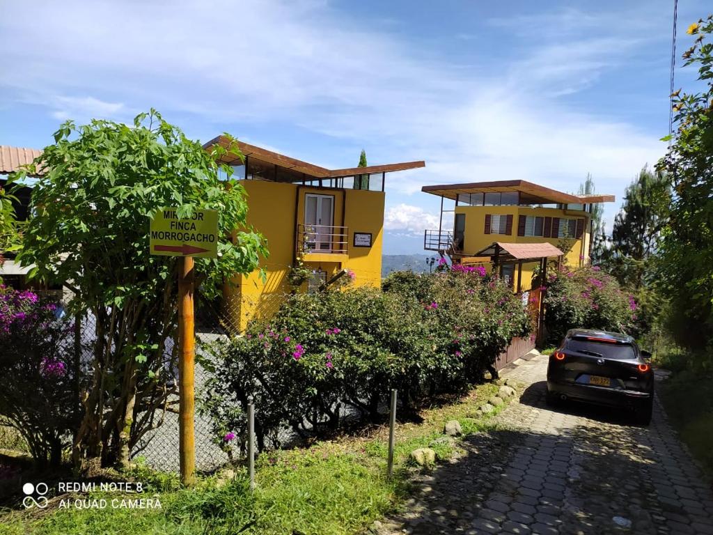un coche aparcado frente a una casa amarilla en Mirador Finca Morrogacho, en Manizales