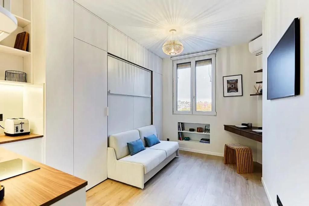 - un salon avec un canapé blanc et des oreillers bleus dans l'établissement Studio charmant à Paris, près de l'Arc de Triomphe, à Paris