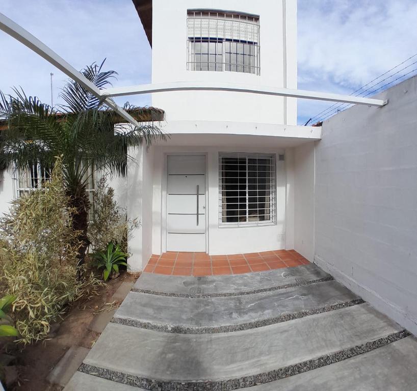 a white house with a door and a palm tree at La Placita in Cordoba