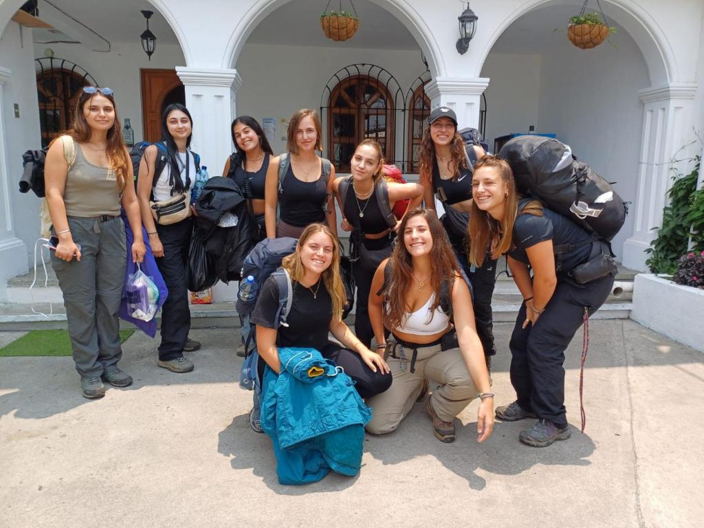 um grupo de mulheres posando em frente a um edifício em Blue Moon Hostel em Antigua Guatemala