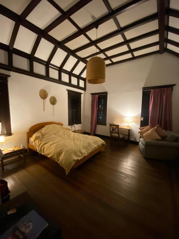 una camera con un letto e un divano di Habitación 1 Casona Ellauri a Montevideo