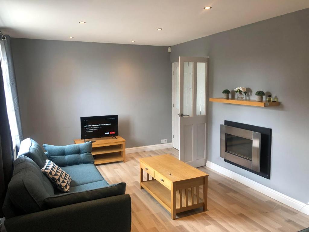 a living room with a couch and a fireplace at Well presented 3 Bed House- 9 Guests - Great for Leisure stays or Contractors -NG8 postcode in Nottingham