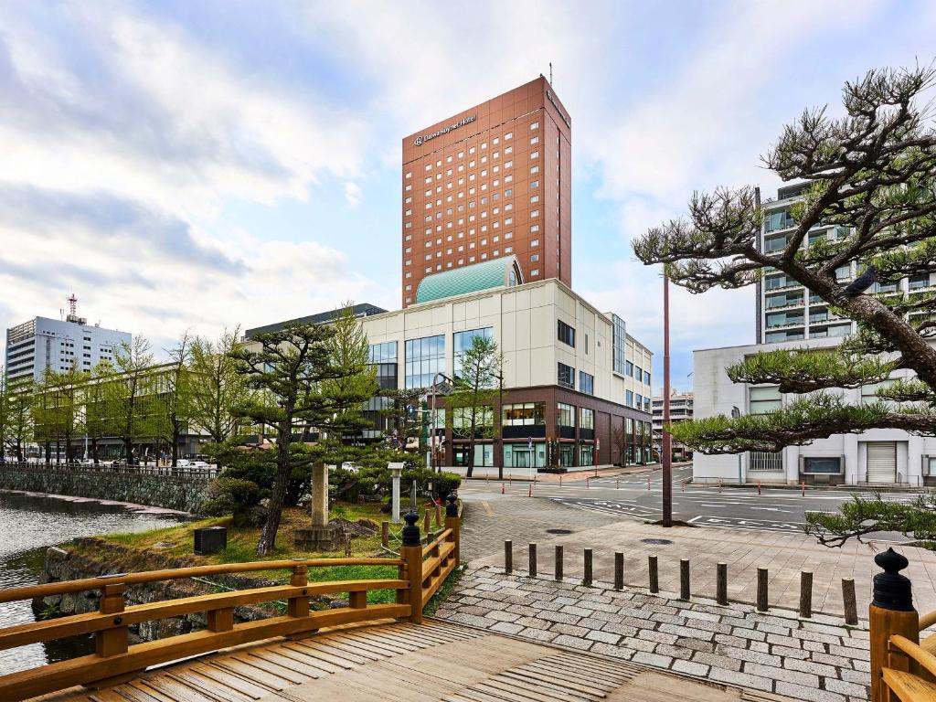 budynek z drewnianym płotem przed nim w obiekcie Daiwa Roynet Hotel Wakayama w mieście Wakayama
