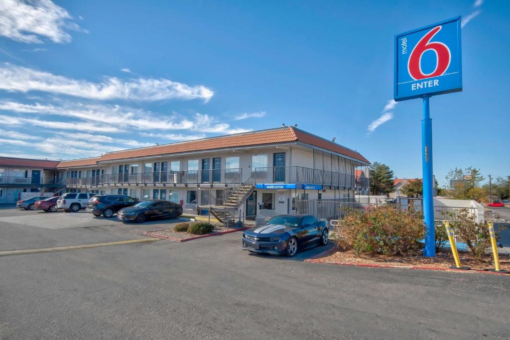 um hotel com carros estacionados em frente a um parque de estacionamento em Motel 6-Albuquerque, NM - Carlisle em Albuquerque
