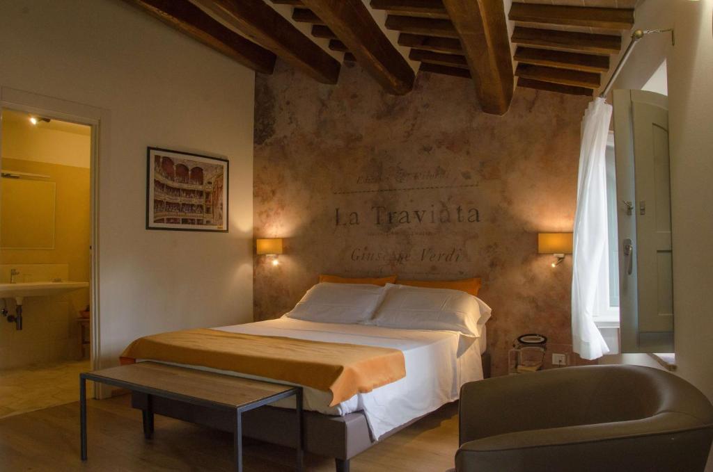 a bedroom with a bed and a table and a chair at Antico Sipario Boutique Hotel, BW Signature Collection in Paciano
