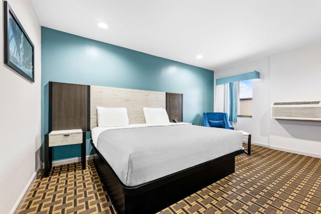 a bedroom with a large bed and a blue wall at SureStay by Best Western Huntsville University Area in Huntsville
