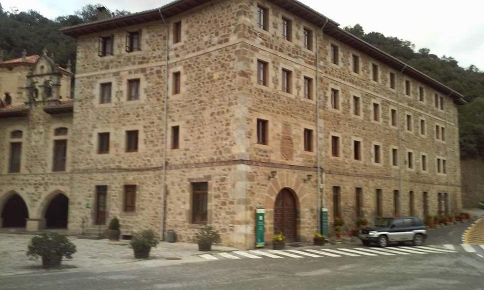 a large stone building with a car parked in front at APARTAMENTO POCO TRIGO EN POTES in Potes