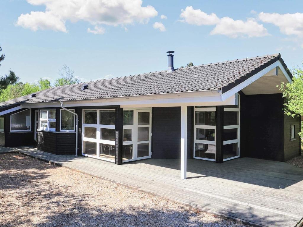 una casa con una terraza de madera frente a ella en 6 person holiday home in lb k, en Ålbæk