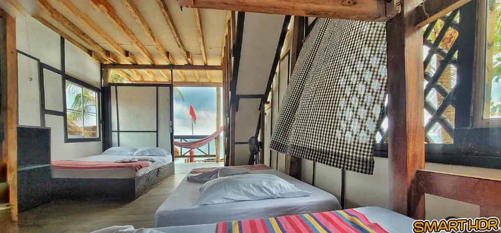 a room with three beds in it with a window at Hostal Punta Cangrejo in San Onofre