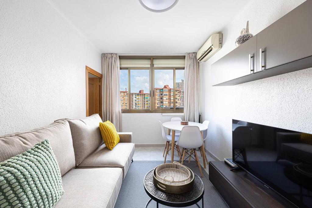 un soggiorno con divano, TV e tavolo di Cozy Apt In Cornella 2 Mins From The Metro a La Gabarra